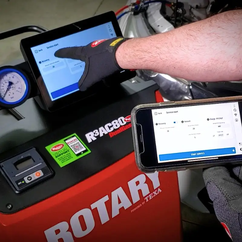 Top 5 Professional Shop Equipment Upgrades to Future-Proof Your Business for 2026 Technician operating the Rotary R3AC80 A/C cart remotely using a mobile phone app for diagnostics.